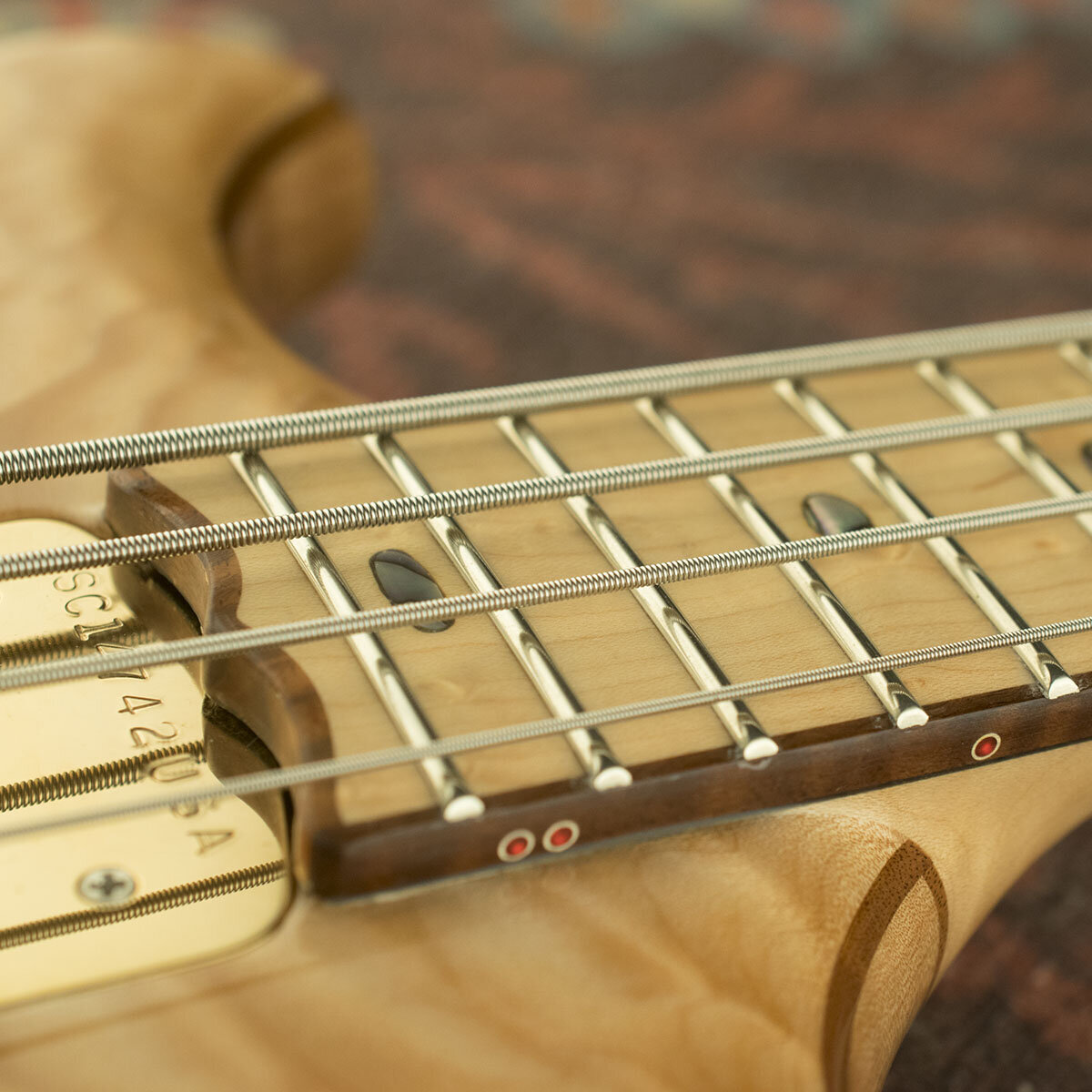 Walnut binding on Bird's-eye Maple fingerboard